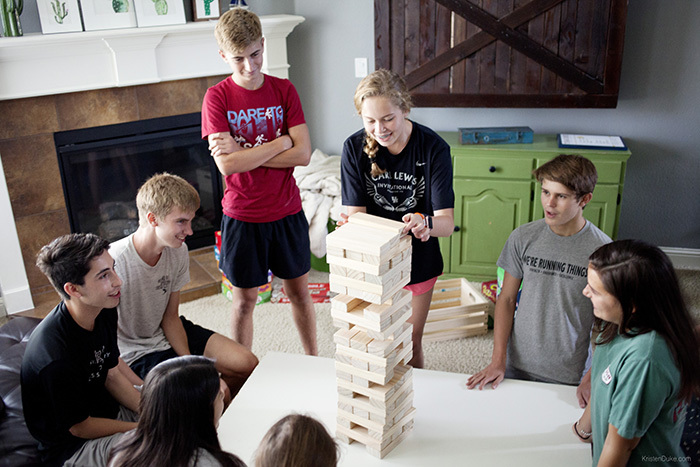An image of teenagers playing a game of Jenga together.