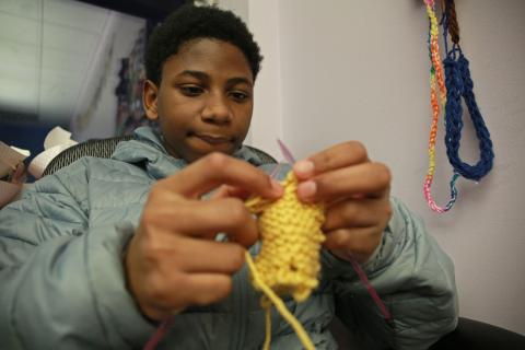 An image of a teenager knitting.